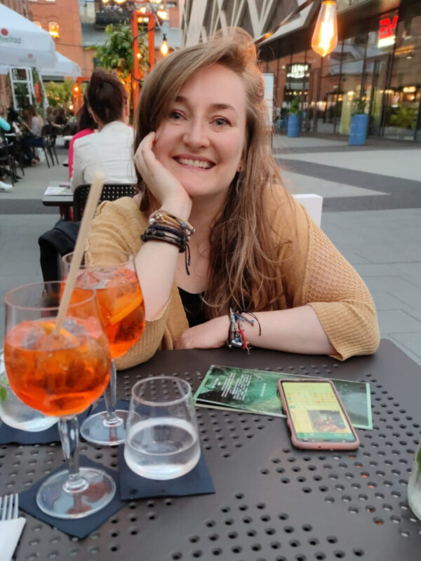 Estera having a drink at a table.